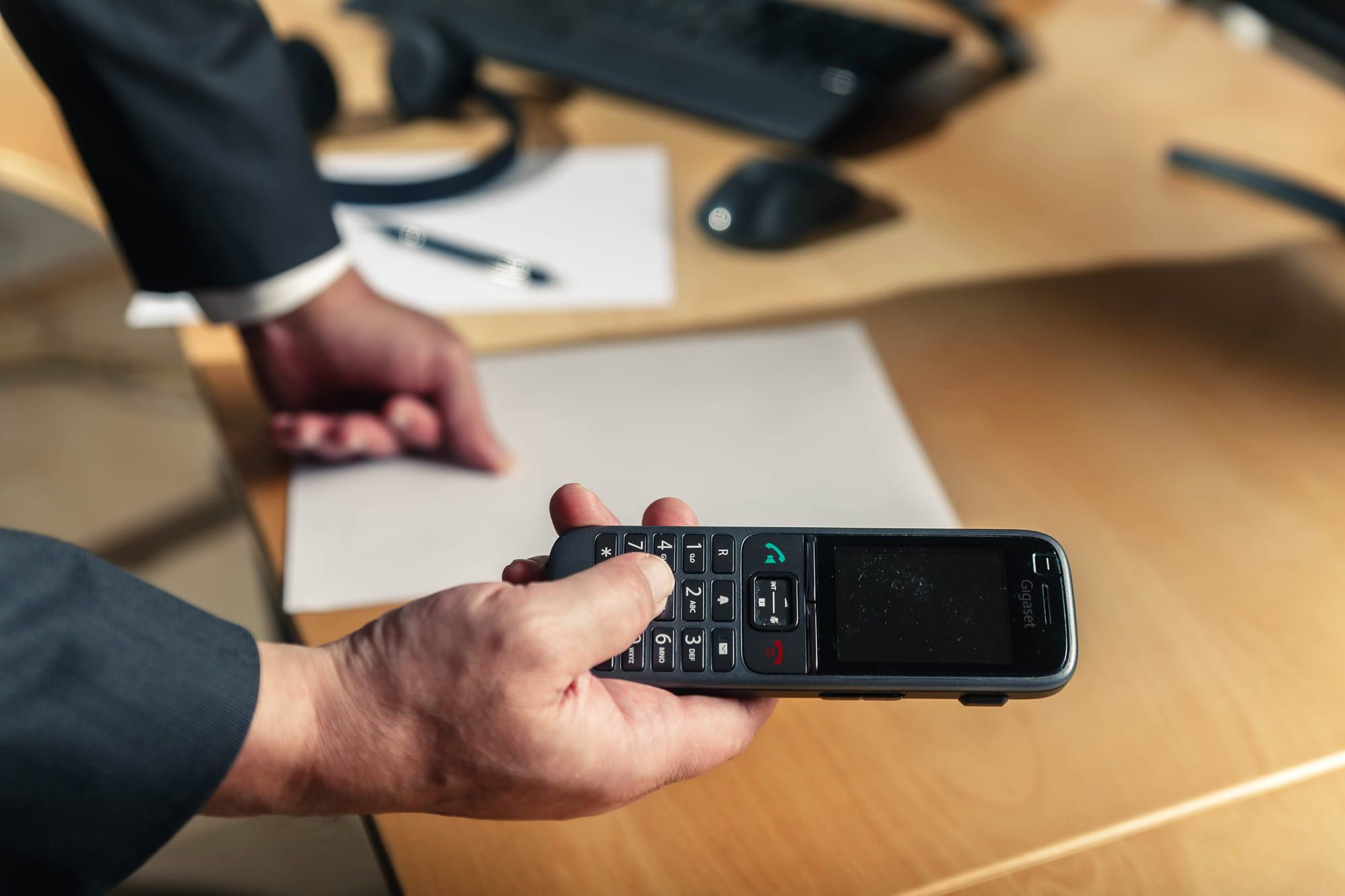 Übergabe eines Telefonhörers am Besprechungstisch